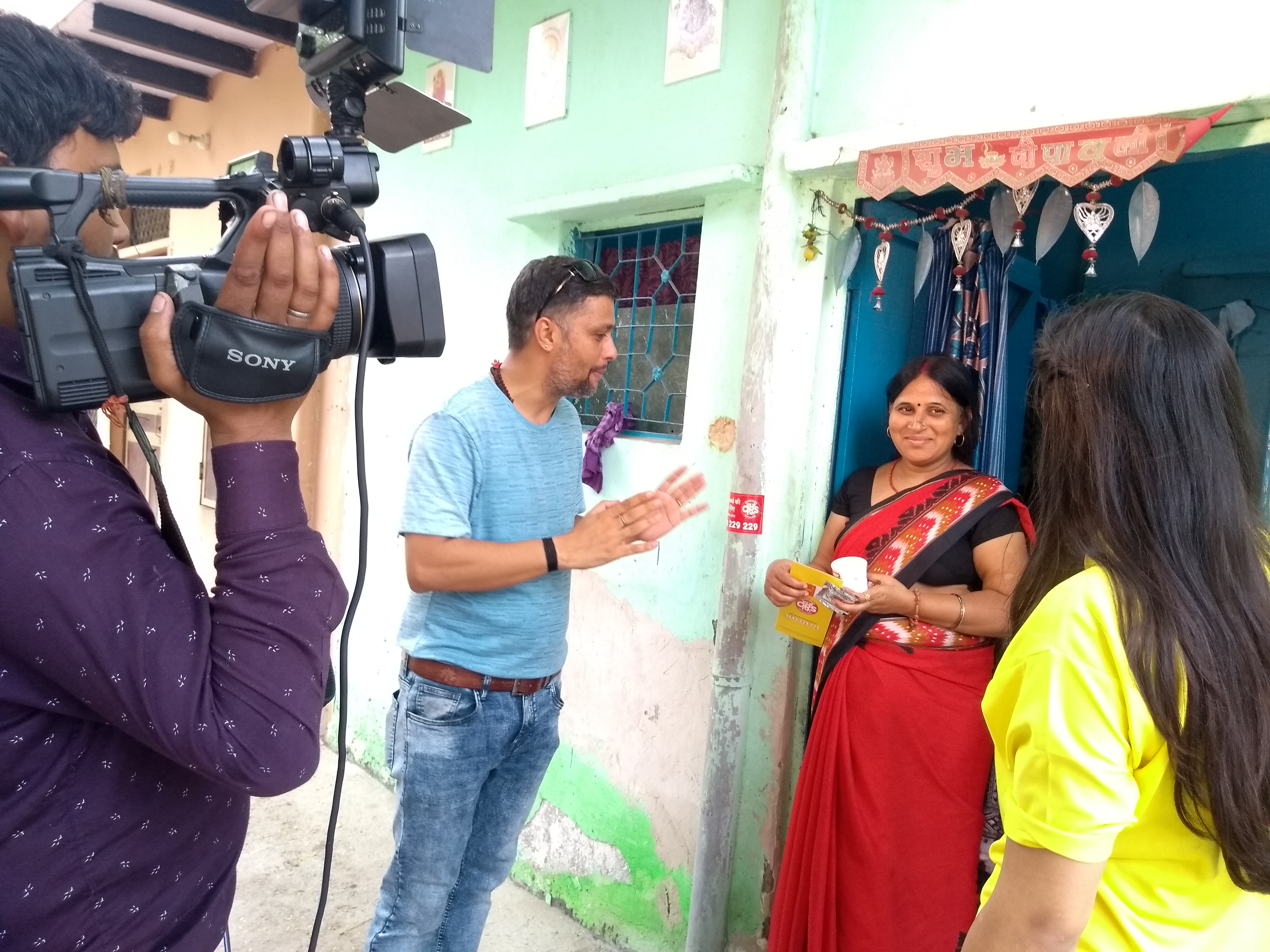 Woman being interviewed by a man and a woman while being filmed